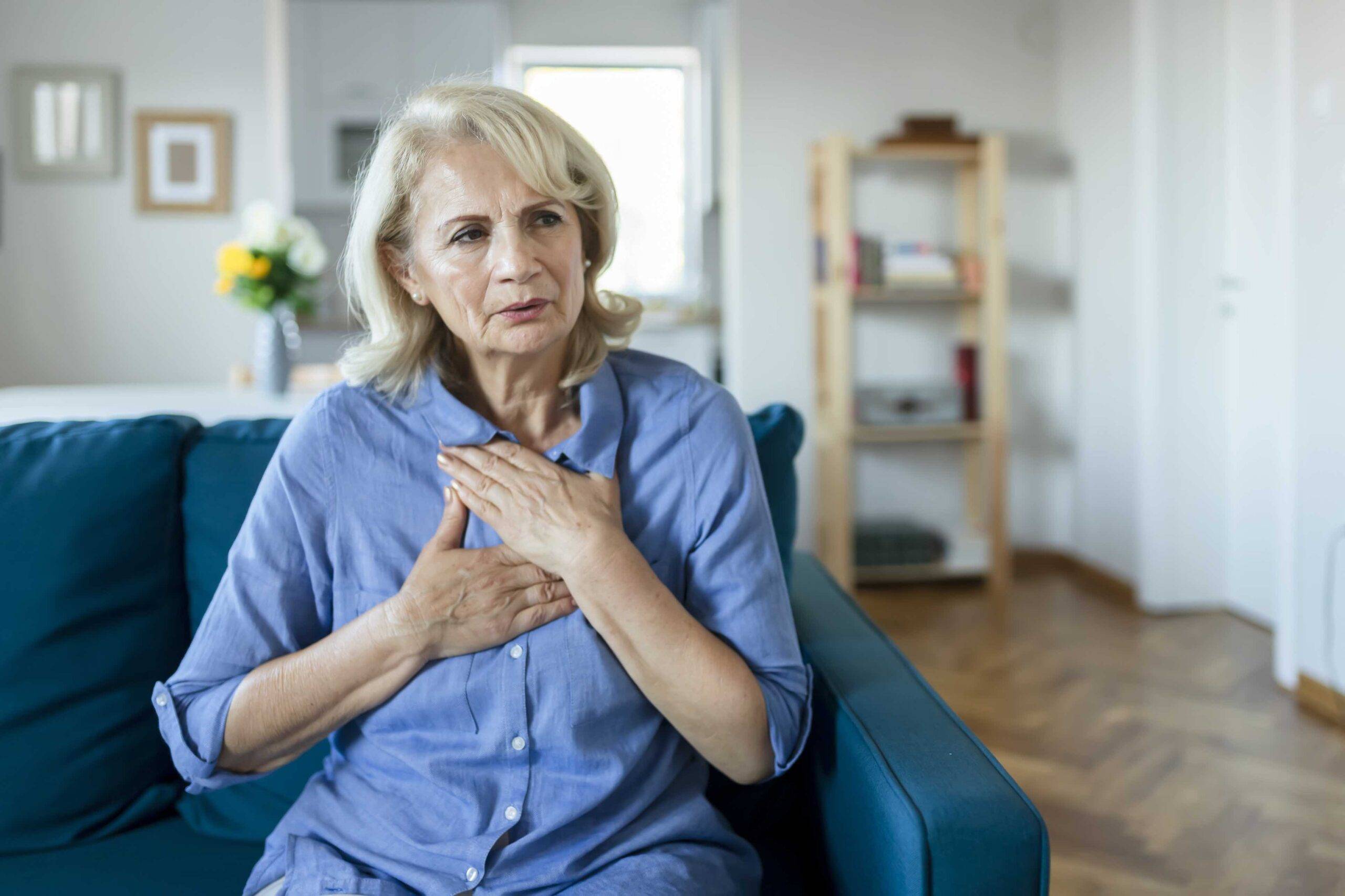 Paciente idosa com fibrilação atrial sente palpitações irregulares do coração e leva mãos ao peito
